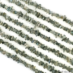 May include: A strand of grey and green labradorite chip beads. The beads are irregular in shape and have a shimmery, iridescent finish.