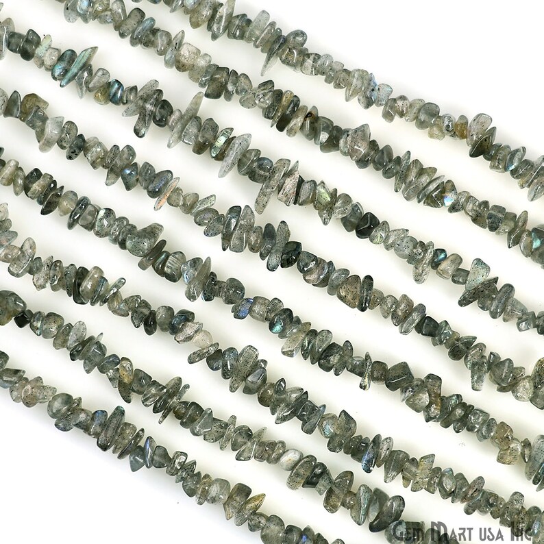 May include: A strand of grey and green labradorite chip beads. The beads are irregular in shape and have a shimmery, iridescent finish.