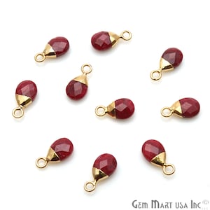 May include: Ten red gemstone teardrop charms with gold-plated jump rings. The charms are approximately 1 inch long and are perfect for jewelry making.