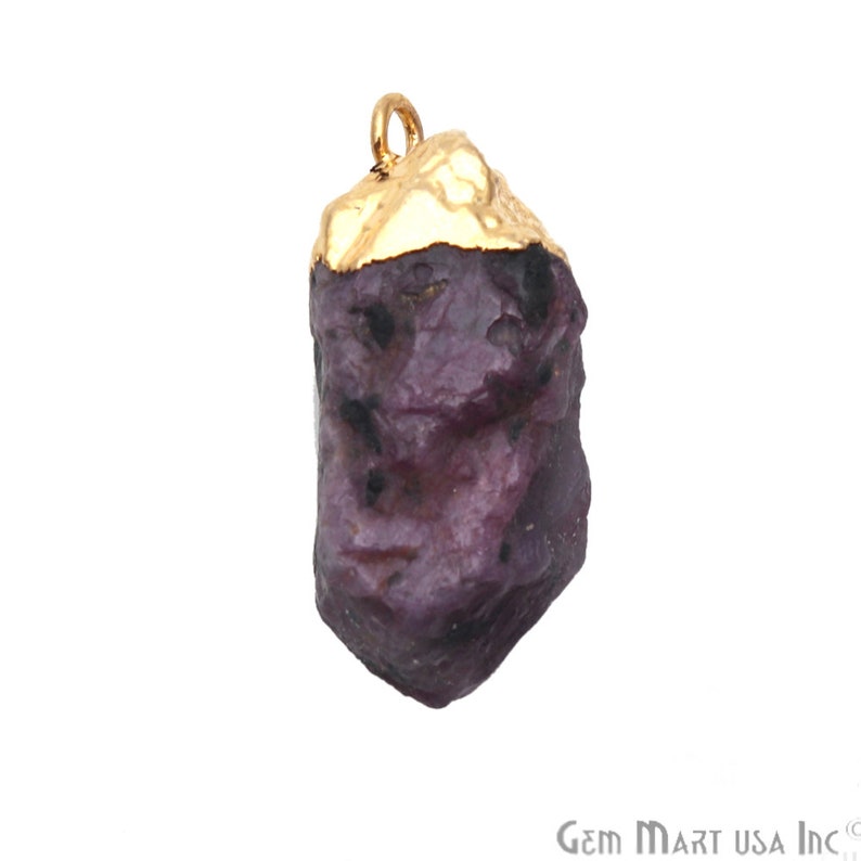 May include: A raw purple gemstone pendant with a gold-plated top. The pendant is irregularly shaped and has a rough, natural texture.