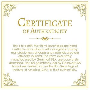 May include: A certificate of authenticity with a gold border and ornate design. The text reads "CERTIFICATE OF AUTHENTICITY". The certificate states that items purchased are hand-crafted in accordance with recognized jewelry manufacturing standards and materials used are ethically sourced. The items are exclusively manufactured by Gemmart USA and natural gemstones sold by GemMartUSA have been tested and verified by the Gemological Institute of America (GIA) for their authenticity.