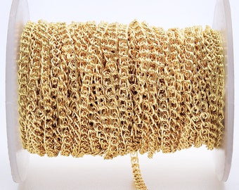 May include: A spool of gold-colored chain, likely for jewelry making. The chain is tightly wound on the spool, and the end of the chain is visible hanging off the spool.