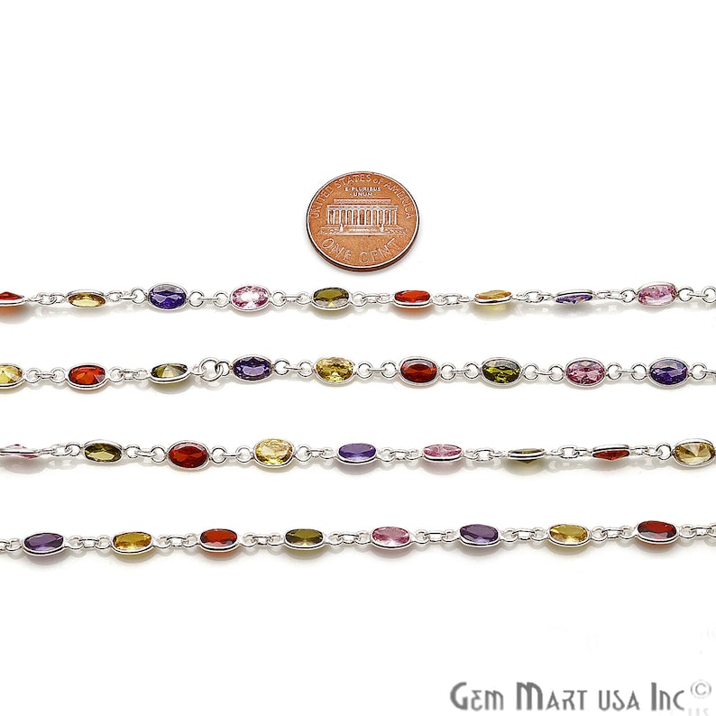 May include: Five strands of silver chain with oval-shaped gemstones in various colors, including purple, pink, red, yellow, and green. A US penny is included for scale.