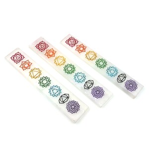 Pode incluir: Três barras retangulares de cor branca translúcida com sete símbolos de chakra distintos impressos em sequência vertical. Cada símbolo é representado numa cor específica, incluindo vermelho, laranja, amarelo, verde, azul claro, azul escuro e roxo.