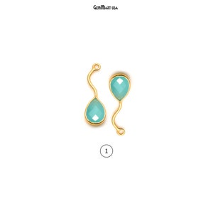 May include: Two gold-tone teardrop-shaped pendants with light blue gemstone accents. The pendants are connected by a curved wire.