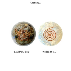 K&ouml;nnte beinhalten: Zwei Kristallkugeln mit Kupferspiralen im Inneren. Die Kugel links ist ein dunkelgr&uuml;ner Labradorit. Die Kugel rechts ist ein wei&szlig;er Opal.