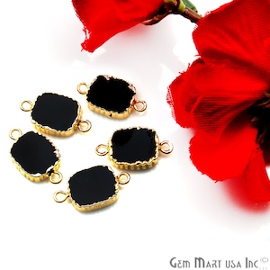 May include: Five black rectangular connector charms with gold-toned edges and jump rings. The charms have a textured, slightly irregular surface.