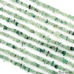 May include: A strand of light green fluorite chip beads. The beads are small and irregular in shape, and they have a translucent appearance. The beads are strung on a clear thread and are ready to be used in jewelry making.