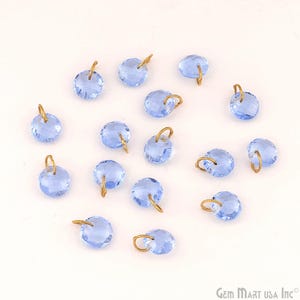 May include: A collection of light blue faceted crystal beads with gold-colored loops. The beads are round and have a sparkling appearance. The image is taken on a white background.