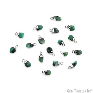 May include: A collection of 17 emerald green gemstone pendants with silver jump rings. The gemstones are rough and natural in shape.