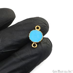 May include: Gold-tone connector with a round, light blue center. The connector has two loops for attaching jewelry.