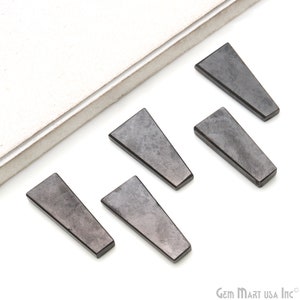 May include: Five black, triangular shaped, gemstone cabochons. The cabochons are smooth and have a slightly textured surface.