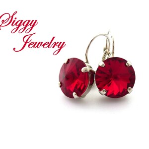 May include: A pair of silver earrings with red crystal stones. The earrings have a simple design and are perfect for everyday wear.
