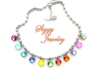 Könnte beinhalten: Eine silberne Kettenkette mit einem Regenbogen aus bunten Kristallperlen. Die Kette liegt auf einem weißen Hintergrund und der Text "Siggy Jewelry" ist im Bild sichtbar.