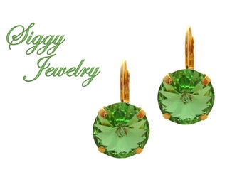 May include: A pair of gold earrings with green crystal stones. The earrings are round and have a faceted design. Siggy Jewelry is written in green text at the top of the image.