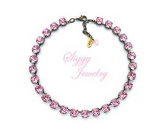 May include: A delicate pink crystal necklace with a brass chain. The necklace is made of small, round crystals that are set close together. The necklace is perfect for adding a touch of sparkle to any outfit.