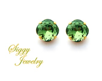 May include: A pair of gold stud earrings with green gemstone accents. The earrings are small and delicate, perfect for everyday wear.