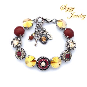 May include: A silver bracelet with a variety of colorful beads, including red, gold, and clear crystals. The bracelet has a charm with a key and heart design. The bracelet is made by Siggy Jewelry.