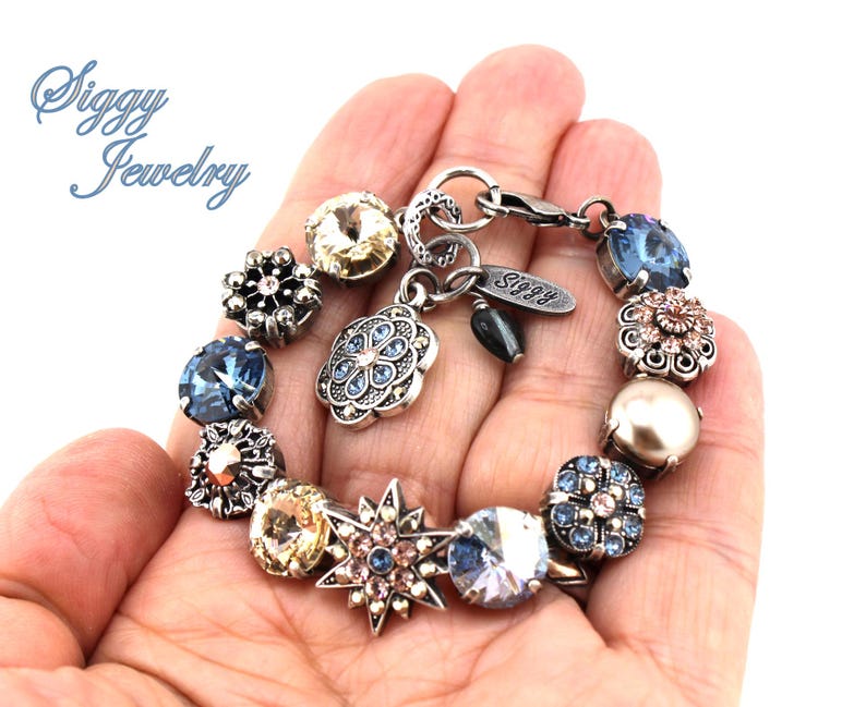 May include: A silver charm bracelet with a variety of charms, including a star, a flower, and a pearl. The bracelet also has a tag that says "Siggy Jewelry".
