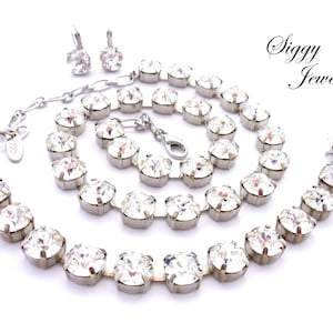 May include: A set of clear crystal jewelry featuring a necklace, bracelet, and earrings. The jewelry is made of silver-toned metal and features large, faceted crystals.