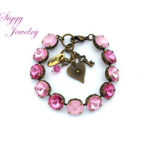 Pode incluir: Um bracelete de cristal rosa com um fecho de cora&ccedil;&atilde;o e chave. O bracelete &eacute; feito de lat&atilde;o antigo e apresenta um degrad&eacute; de cristais rosa.