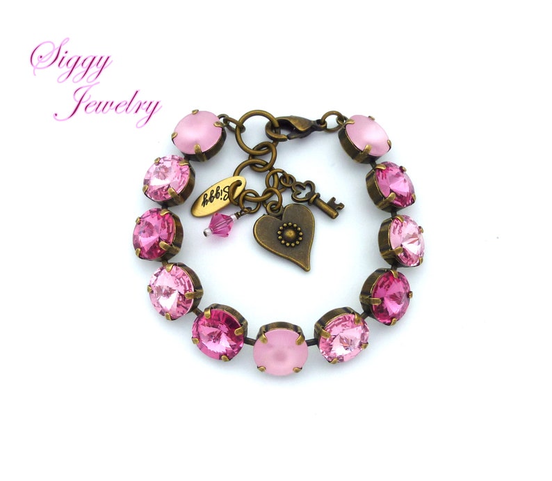 Pode incluir: Um bracelete de cristal rosa com um fecho de cora&ccedil;&atilde;o e chave. O bracelete &eacute; feito de lat&atilde;o antigo e apresenta um degrad&eacute; de cristais rosa.