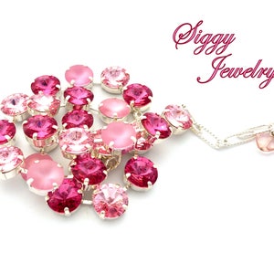Pode incluir: Um bracelete rosa e prateado com uma variedade de contas de cristal. O bracelete tem um pequeno charme com a palavra "Siggy Jewelry" nele.