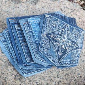 Pu&ograve; includere: Una pila di sottobicchieri in denim, ciascuno realizzato con tasche di jeans riciclate. I sottobicchieri variano nelle tonalit&agrave; di blu, uno dei quali presenta un design a stella ricamato impreziosito da strass. Un articolo di arredamento per la casa sostenibile.