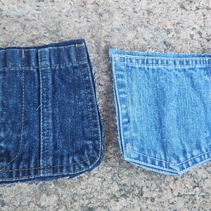 Pu&ograve; includere: Due tasche di jeans in denim, una blu pi&ugrave; scuro e l'altra blu pi&ugrave; chiaro, sono esposte fianco a fianco. Entrambe le tasche hanno cuciture visibili e sono appoggiate su una superficie grigia strutturata.