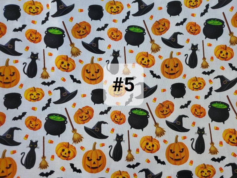 May include: A white fabric with a repeating pattern of black cats, witches' hats, pumpkins, cauldrons, bats, and broomsticks. The fabric has the number "#5" printed on it.