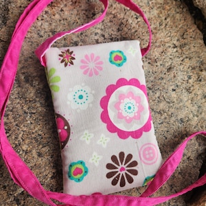 May include: A small pink crossbody bag with a floral print. The bag has a pink strap and a white background with pink, green, brown, and blue flowers.