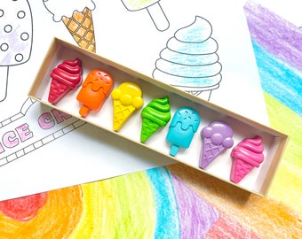 May include: A set of rainbow-colored ice cream crayons in a cardboard box. The crayons are shaped like different types of ice cream, including cones, cups, and popsicles. The box has the words "ICE CREAM" printed on it.
