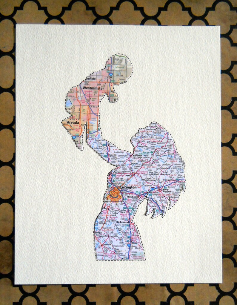 Puede incluir: Una obra de arte en papel que presenta una silueta de madre e hijo recortada de un mapa. La figura de la madre sostiene al ni&ntilde;o en el aire. El mapa muestra carreteras, ciudades y pueblos en tonos azules, verdes y naranjas.