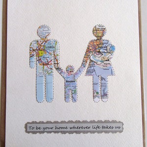 May include: A handmade greeting card featuring a family silhouette cut from map paper. The figures are holding hands, with the text "To be your home wherever life takes us" below. The map includes the cities of Lisbon, Boston, and Detroit.