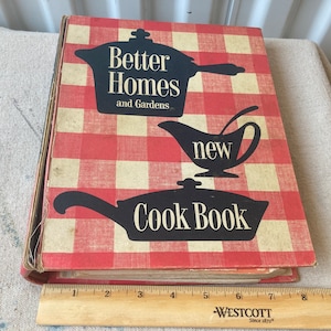 以下が含まれることがあります： 「Better Homes and Gardens new Cook Book」というタイトルの赤と白のチェック柄の料理本。