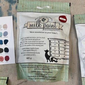 May include: A bag of Miss Mustard Seed's Milk Paint in the color Eclipse. The bag is white with green and black text. The text on the bag reads "Miss Mustard Seed's Milk Paint" and "Move mountains in your home." The bag also includes the text "Made by Homestead House Paint Co."