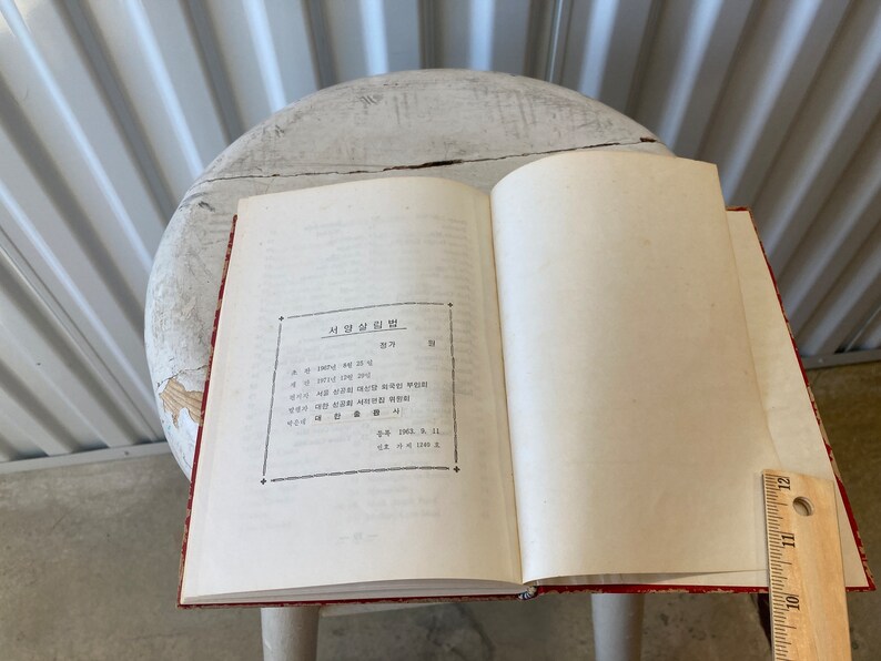 Peut inclure: Un livre ouvert avec une couverture rouge et des pages blanches. Le livre est intitul&eacute; "사명과 비전" en cor&eacute;en. Le texte sur la page est en cor&eacute;en.