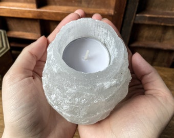 Può includere: Un portacandele in sale dell'Himalaya bianco con una piccola candela tealight bianca all'interno. Il portacandele ha la forma di una roccia naturale ruvida.