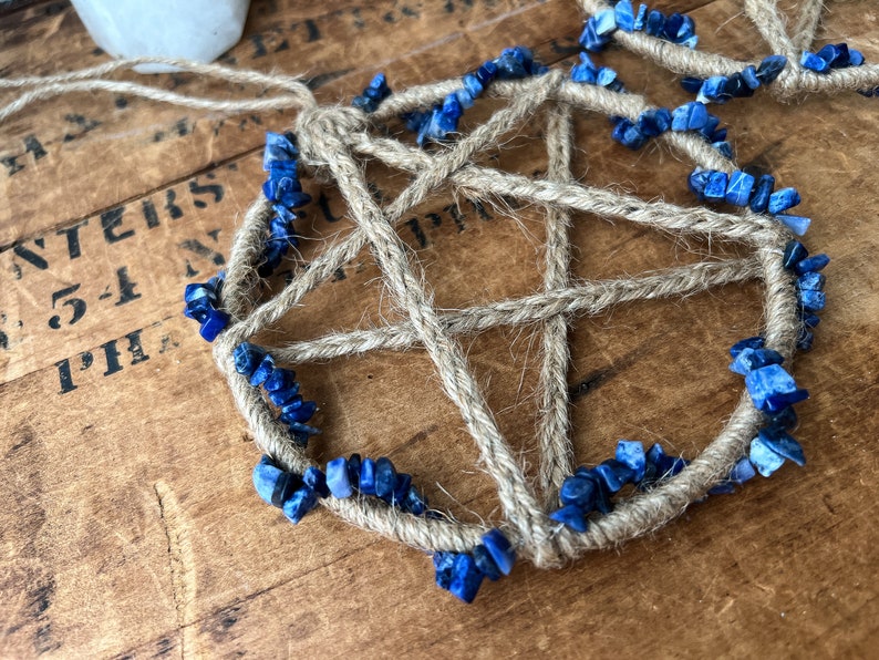 May include: A handmade dreamcatcher with a five-pointed star design, woven with natural twine and accented with blue lapis lazuli stones.