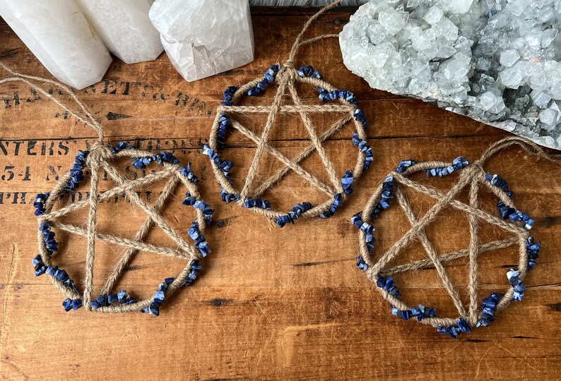 May include: Three handmade pentacle charms with blue lapis lazuli stones woven into the jute twine.