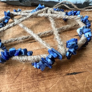 May include: A blue and white crystal dreamcatcher with a jute rope base. The crystals are arranged in a circular pattern around the rope.