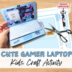 May include: A printable craft activity for kids to make a cute blue gamer laptop. The printable includes a laptop design with a keyboard, screen, and a 'READY' sticker. The printable also includes a 'GAME OVER' sticker and a pair of scissors.