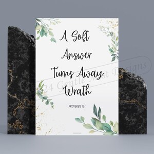 May include: A white printable sign with green watercolour leaves and gold glitter. The text reads "A Soft Answer Turns Away Wrath" with the scripture reference "Proverbs 15:1".