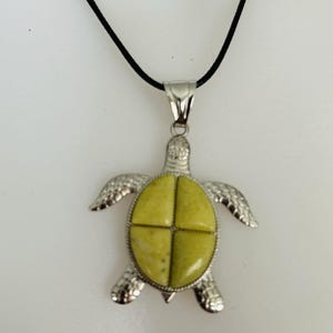 May include: A silver turtle pendant necklace with a green and white stone inlay. The necklace has a black cord.