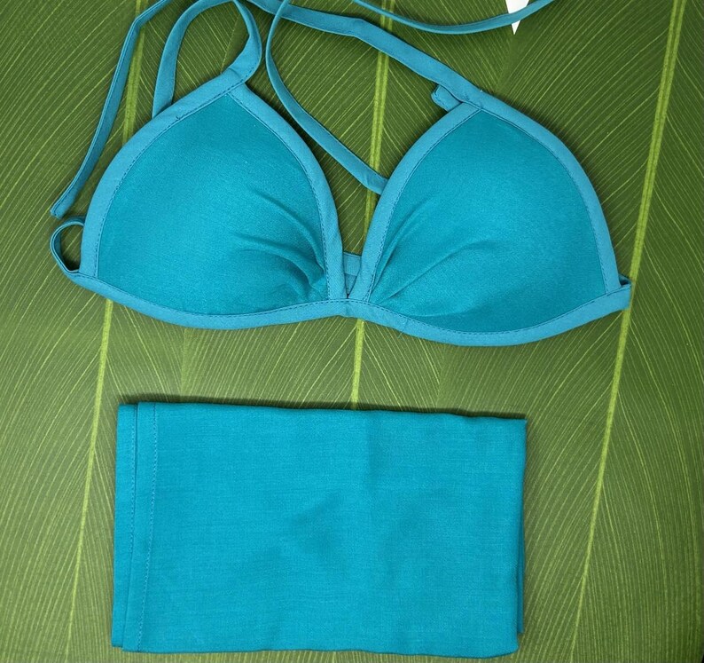 May include: A teal blue bikini top and bottom. The top is a triangle style with adjustable straps. The bottom is a simple, solid piece.