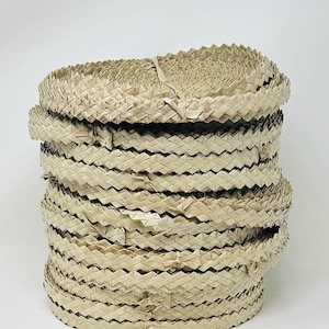 May include: A stack of woven, natural-colored, straw-like material, possibly for crafting or making baskets.