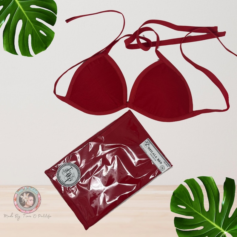 May include: Red triangle bikini top with adjustable straps. The bikini top is packaged in a clear plastic bag with a red fabric liner and a white label that says "Thillala Red".