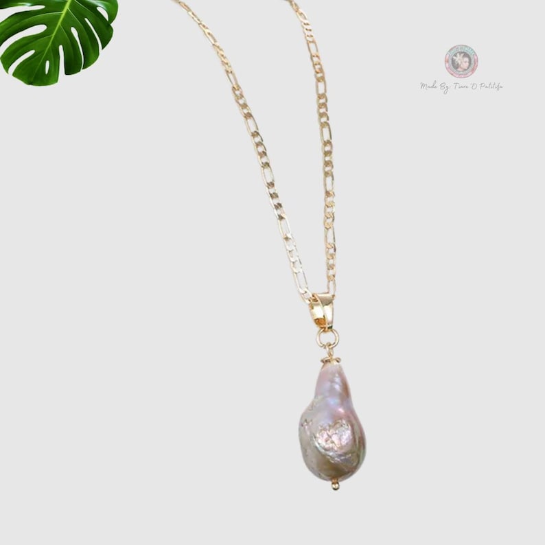 May include: A gold chain necklace with a large, pearlescent, baroque pearl pendant.