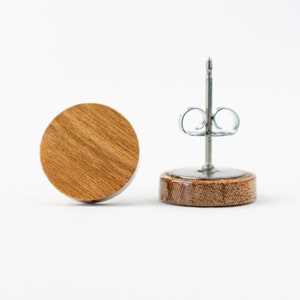 May include: A pair of round wooden earrings with a silver post and butterfly back.