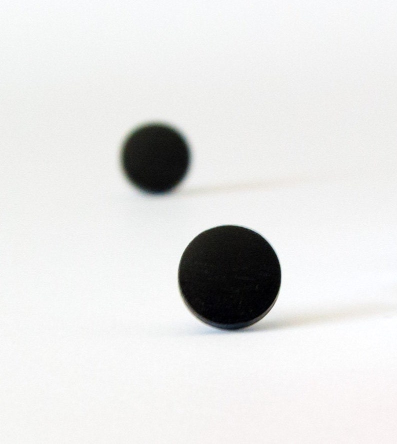 May include: Two black round stud earrings.